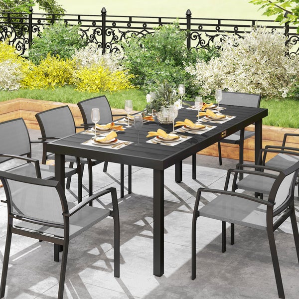 Modernes Gartenmöbel-Set auf einer Terrasse, bestehend aus einem großen rechteckigen Tisch in Anthrazit und acht Stapelstühlen aus Metall und Textil.