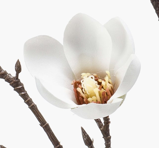 Künstliche Magnolienblüte in Weiß an einem braunen Zweig.