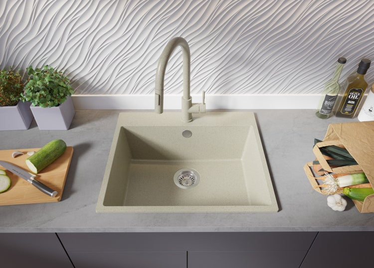 Küchenszene mit Spüle aus Quarzkomposit, Armatur, Gemüse und Küchenutensilien auf einer Arbeitsplatte