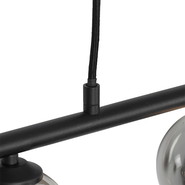 Detailaufnahme einer Pendelleuchte mit schwarzer Aufhängung und Lampenschirmen.