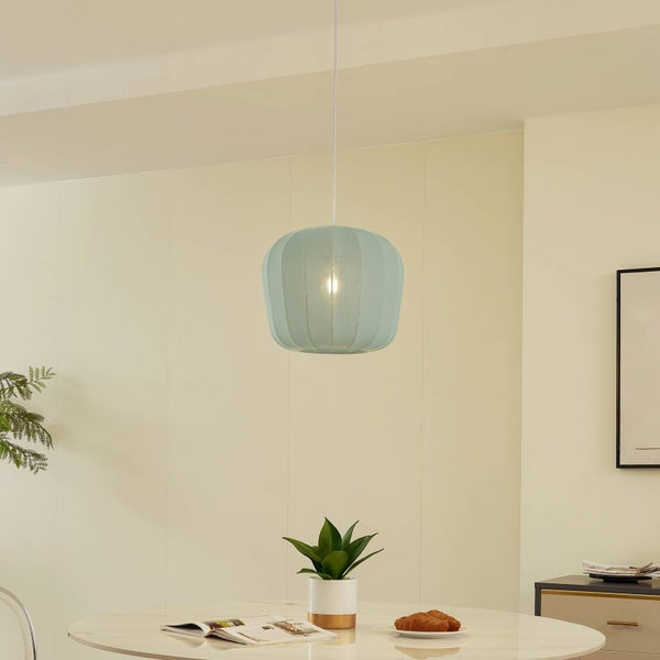 Moderne Pendelleuchte mit hellblauem, geripptem Schirm über einem runden Esstisch in einem hellen, minimalistischen Raum.