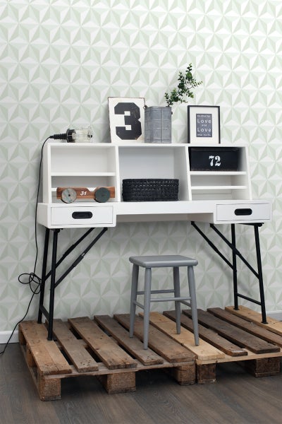 Schreibtisch mit Regalen und Hocker auf Holzpaletten vor gemusterter Wand