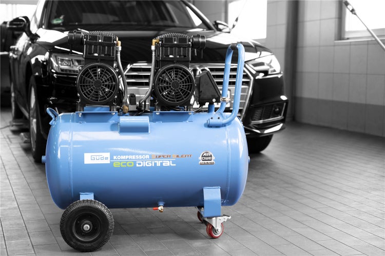 Blauer Güde Kompressor Super Silent Eco Digital vor einem Auto