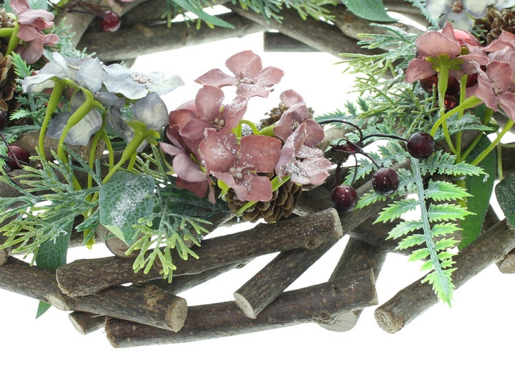 Dekorativer Adventskranz aus Holz mit Kunstblumen, Beeren und Tannenzapfen als weihnachtliche Tischdekoration.