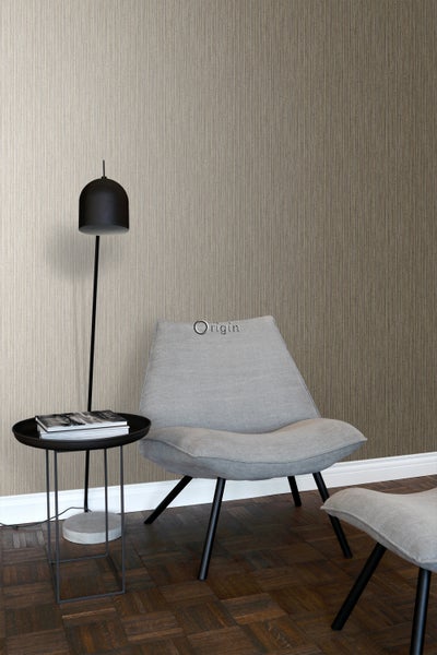 Wohnzimmer-Szene mit brauner Tapete, Lampe, Tisch und Sessel