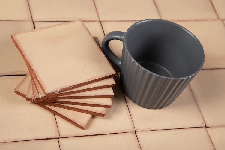 Stapel Terrakottafliesen mit einer grauen Tasse