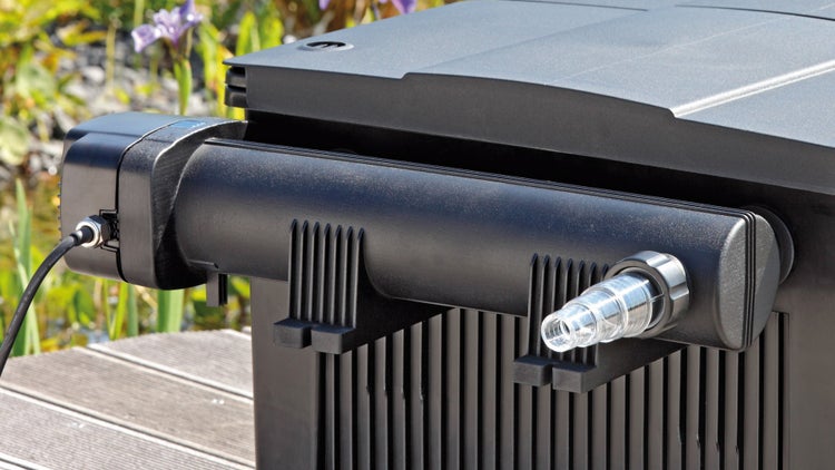 Schwarzer Teichfilter mit Ultraviolett-Klärgerät aus Kunststoff auf einem Holzsteg im Außenbereich mit transparentem Schlauchanschluss.