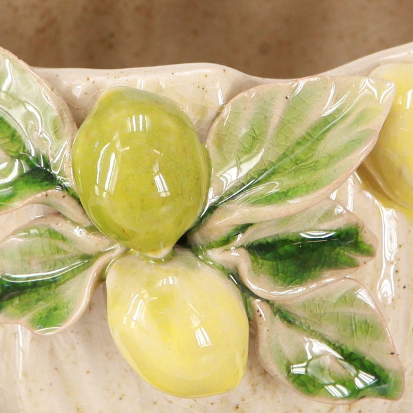 Detailansicht eines Keramik-Übertopfs mit plastischem Zitronen- und Blattdekor.