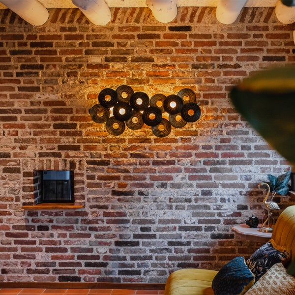 Wandleuchte an Ziegelwand in einem Wohnraum.