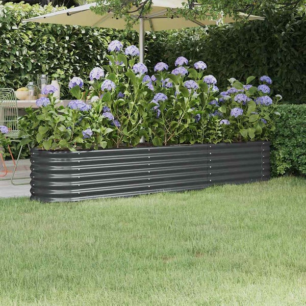 Längliches Hochbeet aus Metall mit Wellenprofil in einem Garten mit Hortensien bepflanzt auf einer Rasenfläche.