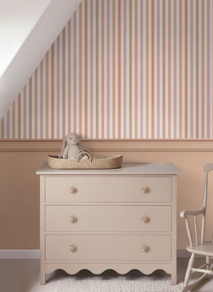 Moderner, heller Wohnraum mit einer Tapetenbordüre mit Baumzeichnungen, einem Holzsessel mit weißem Kissen und einem minimalistischen Beistelltisch.