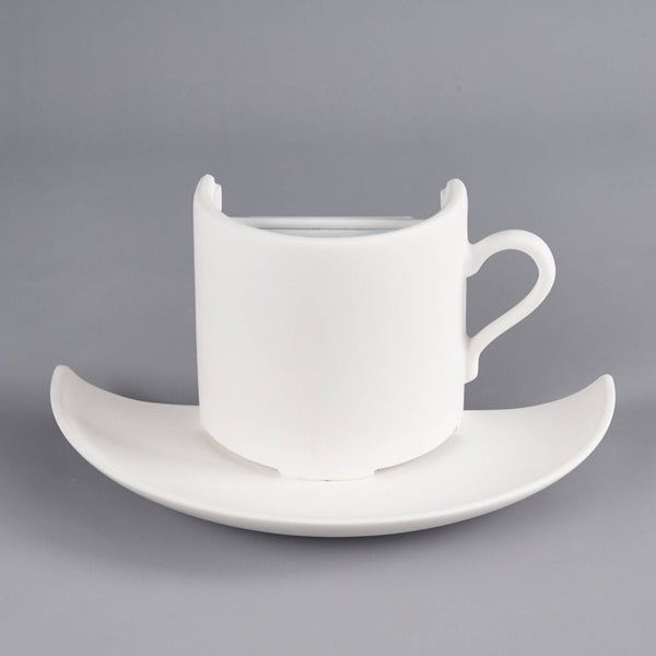 Weiße Wandleuchte in Form einer Kaffeetasse mit Untertasse.