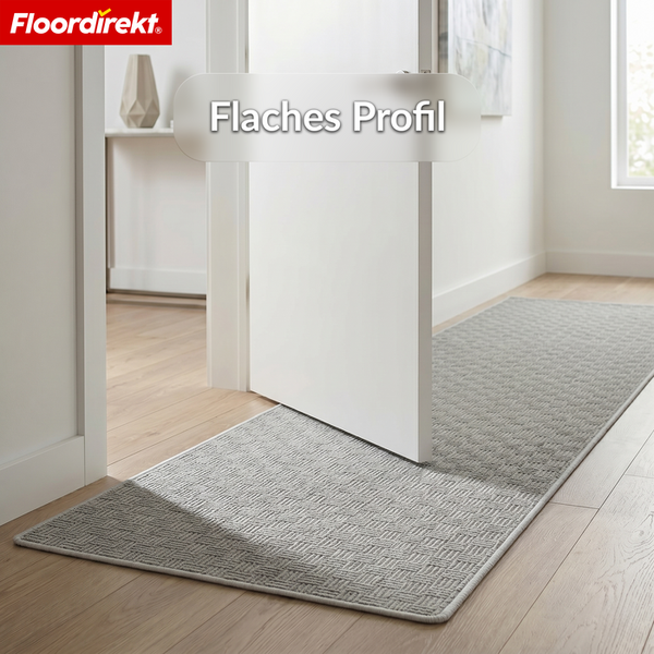 Floordirekt Logo. Flacher Teppichläufer mit gewebtem Muster in hellem Flur unter einer Tür, flaches Profil ermöglicht ungehindertes Türöffnen.