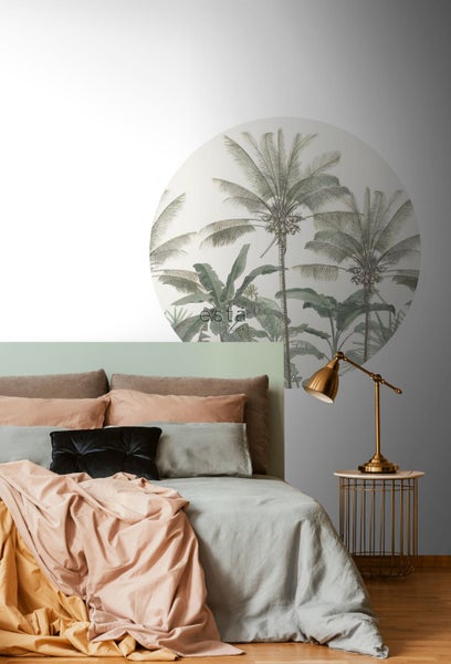 Dekoratives Schlafzimmer mit tropischer Wandtapete, Bett und Nachttischlampe.