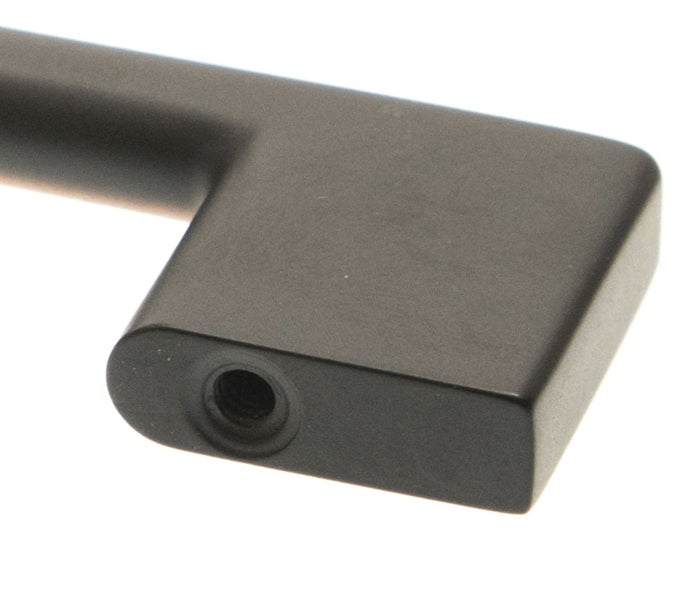 Detailansicht eines kantigen Möbelgriffs aus Metall mit Montagebohrung