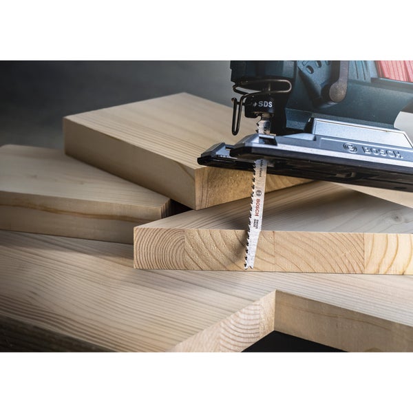 Stichsäge schneidet Holzbrett. Bosch Logo.