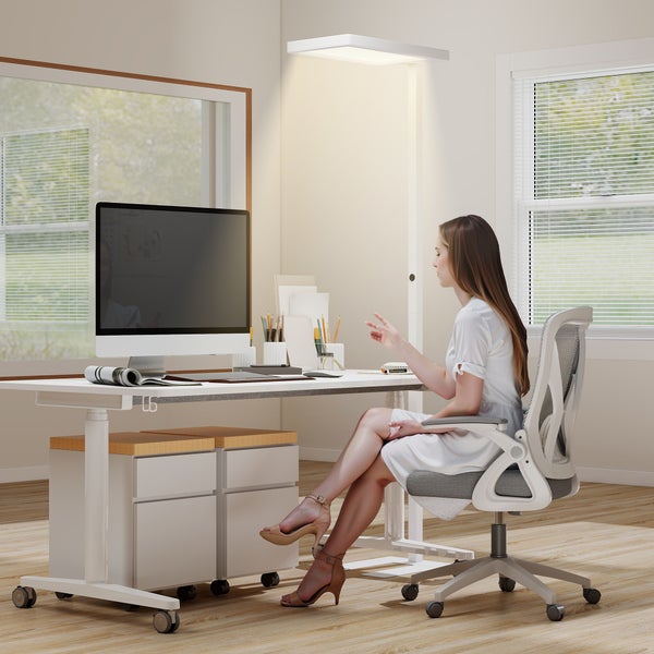 Arbeitszimmer mit höhenverstellbarem Schreibtisch, Bürostuhl und Beleuchtung