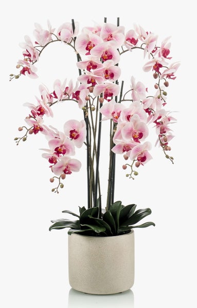 Künstliche Phalaenopsis Orchidee mit rosa Blüten in einem grauen zylindrischen Topf.