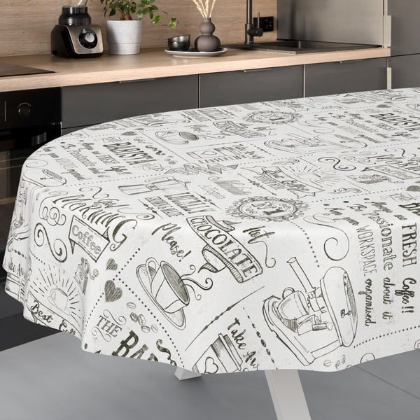 Runde Wachstuchdecke mit Kaffee-Motiven und Schriftzügen in einer modern eingerichteten Küche mit Arbeitsplatte in Holzoptik.