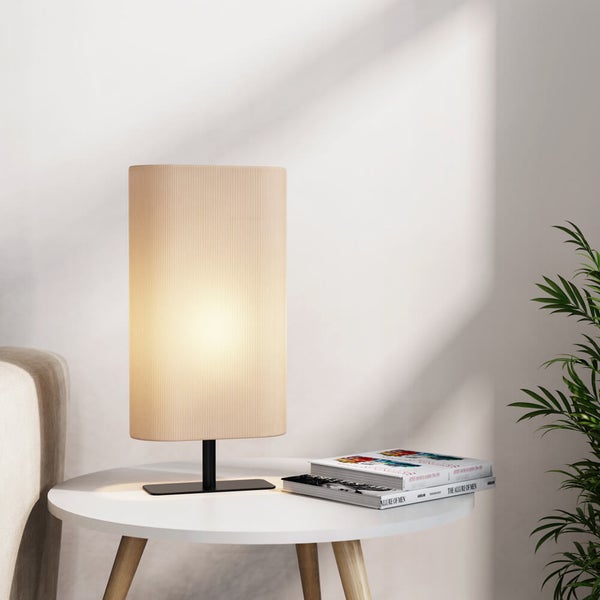 Nachttischlampe auf einem Beistelltisch mit Buch und Pflanze