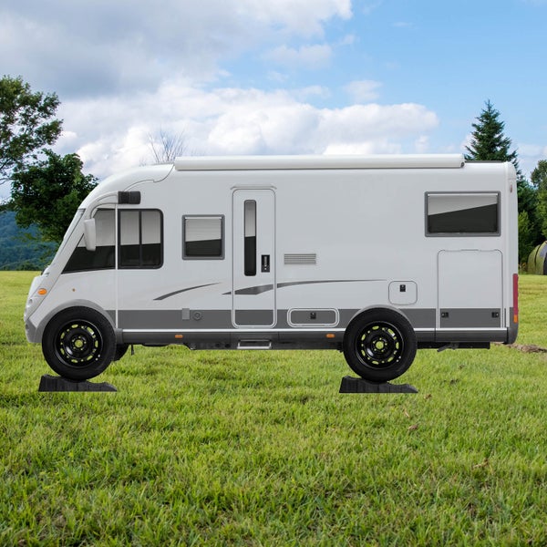 Wohnmobil mit Unterlegkeilen auf einer Wiese