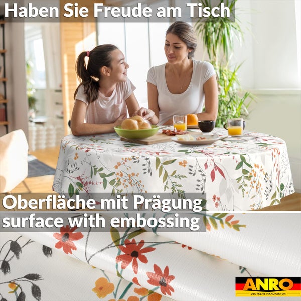 Runde Tischdecke mit Blumenmuster und geprägter Oberfläche in einem hellen Esszimmer mit Personen. ANRO Logo.