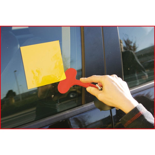 Hand mit Saugnapf-Werkzeug an einer Autoscheibe mit gelbem Notizzettel