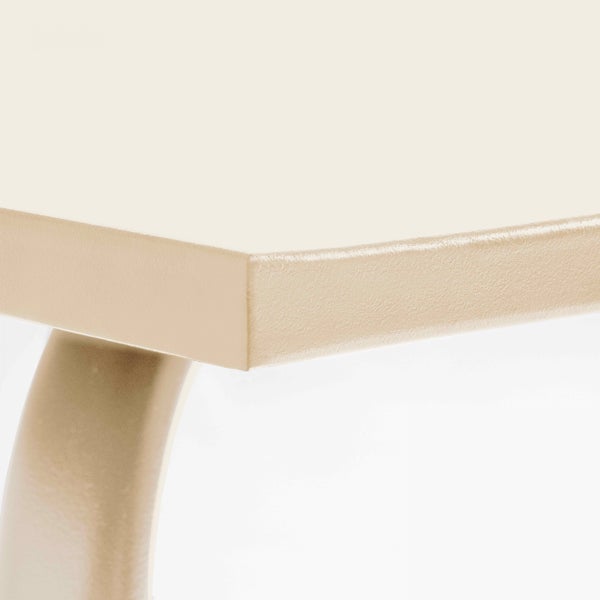 Nahaufnahme einer beigen Tischkante und eines Tischbeins aus pulverbeschichtetem Metall.