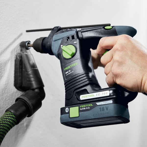 Festool Akku-Bohrhammer beim Bohren in eine Wand, angeschlossener Staubsauger