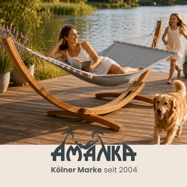 Frau entspannt in Hängematte mit Holzgestell auf Holzterrasse am See, Kind und Hund im Hintergrund. AMANKA Logo.