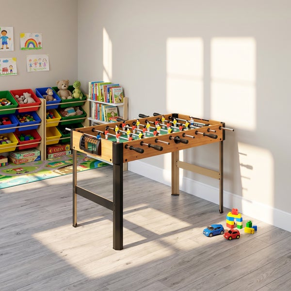 Moderner Tischkicker in Holzoptik mit schwarzen Beinen in einem hellen Kinderzimmer mit Spielzeugregal und Laminatboden.
