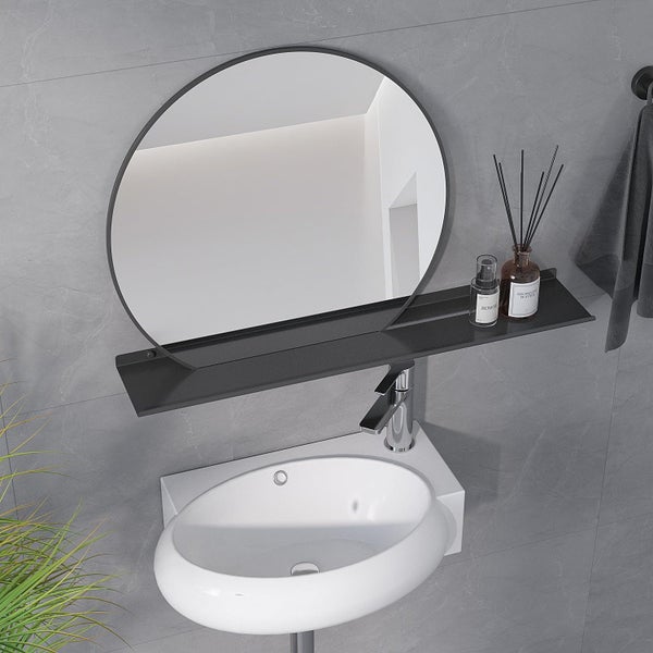 Badezimmer mit rundem Spiegel, Ablageboard und ovalem Waschbecken vor grauen Wandfliesen. Modernes Design mit Armatur und Accessoires.