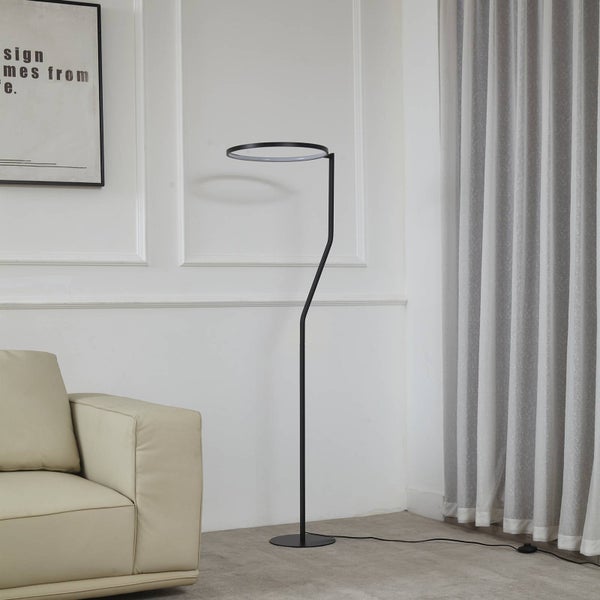 Moderne schwarze Stehleuchte mit ringförmigem LED Kopf in einem hellen Wohnzimmer neben einem hellen Sofa.