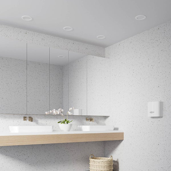 Modernes Badezimmer mit Doppelwaschbecken, großem Spiegelschrank, Holzwaschtisch, Papierhandtuchspender und Terrazzo-Wänden.