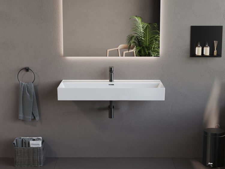 Modernes Badezimmer mit weißem rechteckigem Wand-Waschbecken, schwarzer Armatur und hinterleuchtetem Spiegel vor grauer Wand.