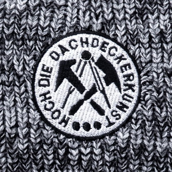 Gesticktes Zunftzeichen für das Dachdeckerhandwerk auf Strickstoff mit dem Schriftzug Hoch die Dachdeckerkunst.