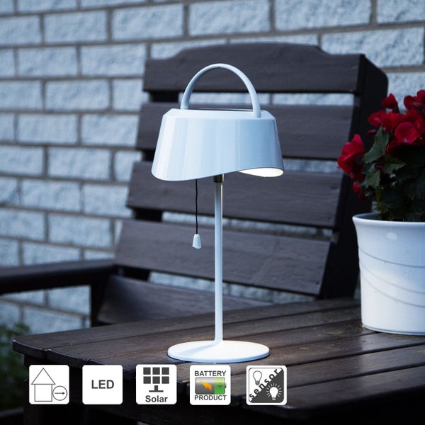 Zwei hängende Papiersterne mit Punktmuster neben einem Weihnachtsbaum