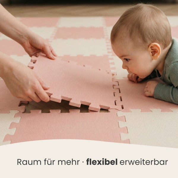 Baby auf einer weichen Schaumstoff-Puzzlematte, während Hände ein Teil einfügen. Der Text lautet: Raum für mehr, flexibel erweiterbar.