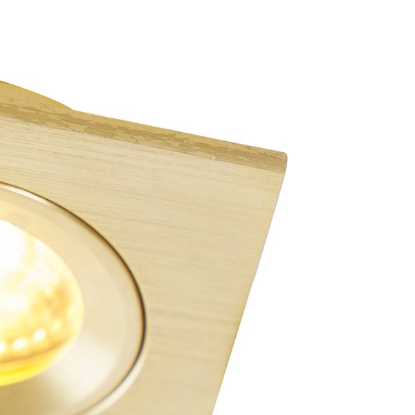 Nahaufnahme eines quadratischen LED-Einbaustrahlers aus gebürstetem Messing mit leuchtendem Leuchtmittel.