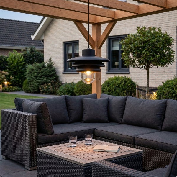 Helle, organisierte Garten-Lounge unter einer Holzpergola mit grauem Ecksofa aus Polyrattan, Holztisch und schwarzer Hängeleuchte.