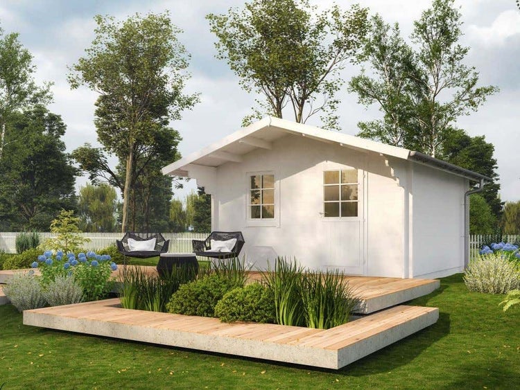 Weißes Gartenhaus aus Holz mit Satteldach, Tür und Fenster auf einer Holzterrasse in einem begrünten Garten mit Sitzgruppe.
