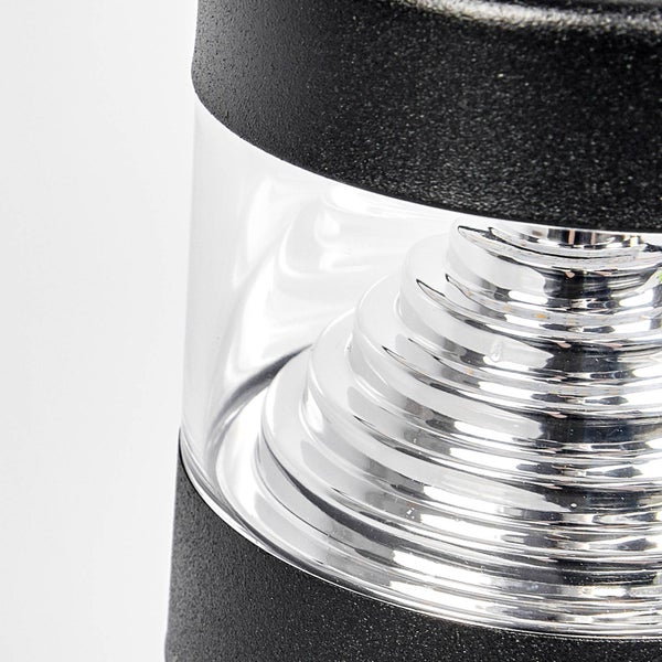 Nahaufnahme einer Außenleuchte mit schwarzem Gehäuse, klarem Glas und silbernem Stufenreflektor im Inneren.
