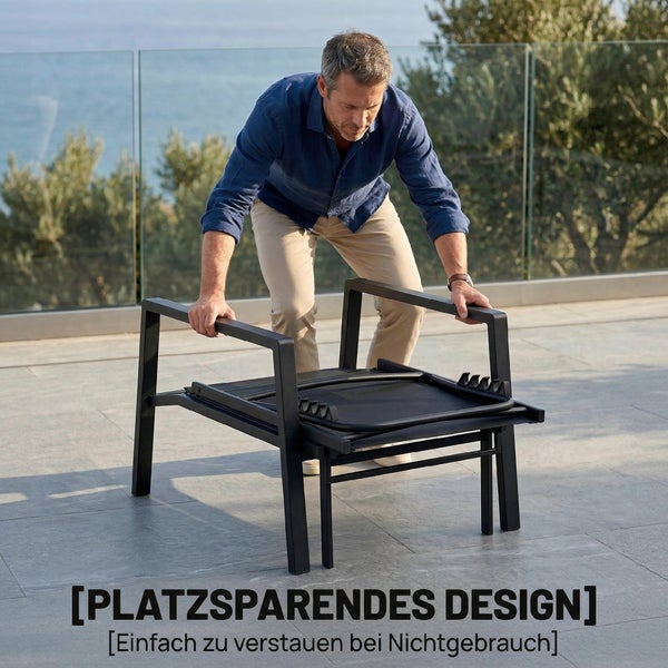 Ein Mann klappt einen Gartenstuhl aus Metall auf einer Terrasse platzsparend zusammen, ideal zum Verstauen bei Nichtgebrauch.