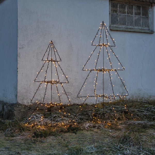 Zwei dekorative, beleuchtete Weihnachtsbaumfiguren im Garten
