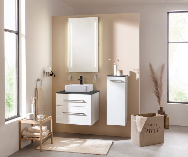 Helles Badezimmer mit Waschbecken, Spiegel, Waschtischunterschrank und Wäschekorb