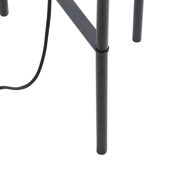 Detailaufnahme eines schwarzen Lampenfußes mit Kabel