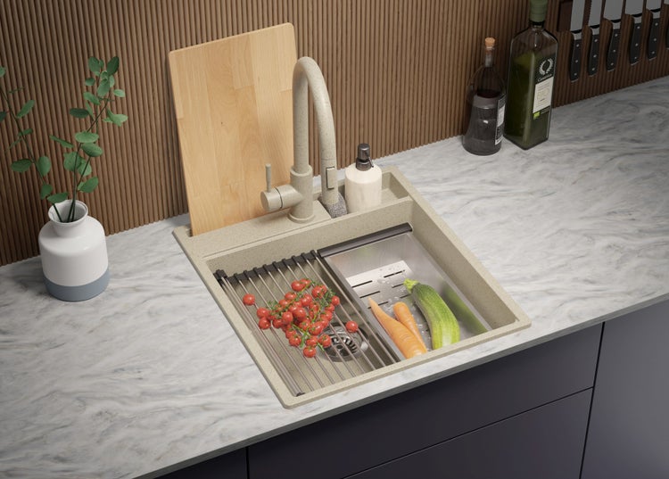 Küchenspüle mit Armatur, Abtropfgestell und frischem Gemüse auf einer Küchentheke.