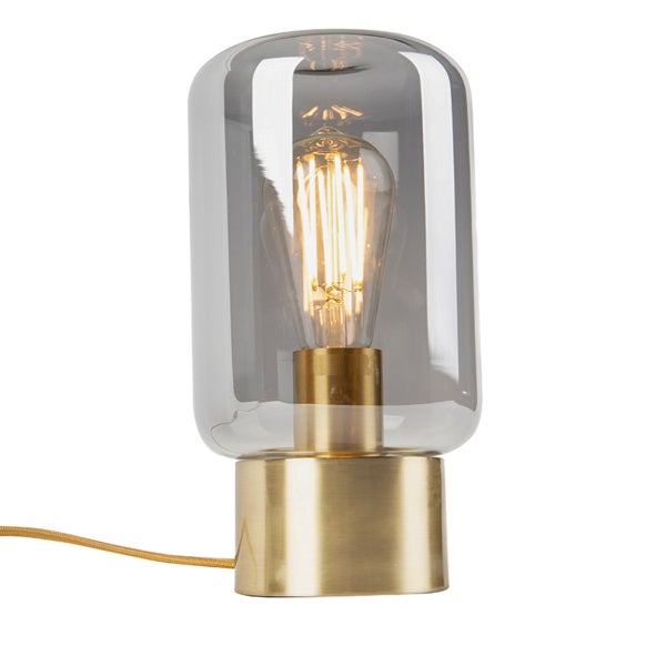 Tischleuchte mit rauchgrauem Glaszylinder und goldfarbenem Metallfuß inklusive Filament-Leuchtmittel.