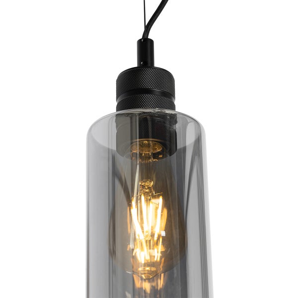 Pendelleuchte mit rauchfarbenem Glaszylinder, schwarzer Metallfassung und leuchtendem LED Filament Leuchtmittel.