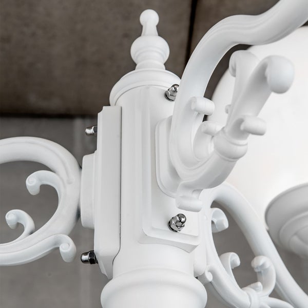 Detailaufnahme einer weißen Außenleuchte mit dekorativ geschwungenen Armen im klassischen Design.